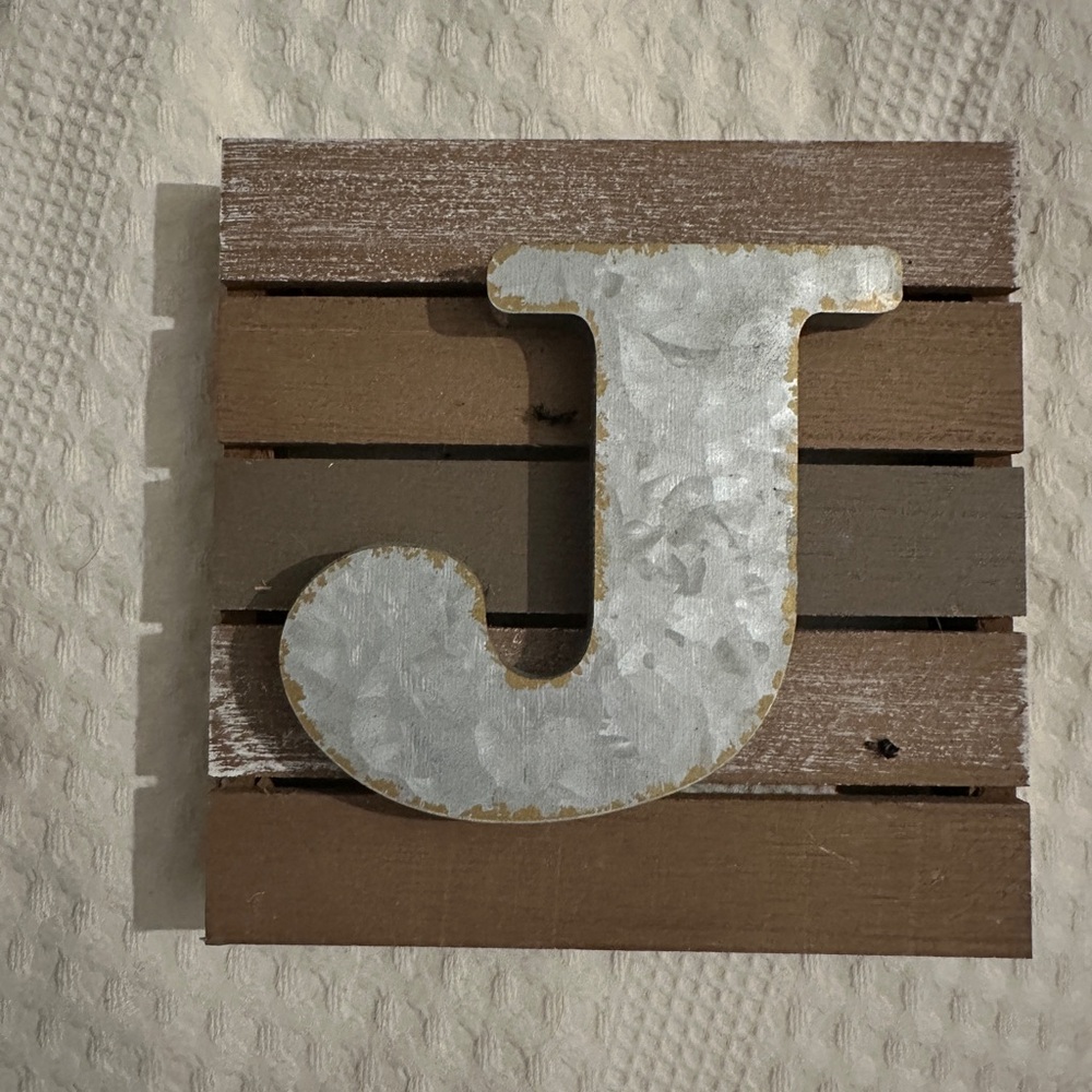 Decorative wooden letter J. Rustic design with a metallic finish.